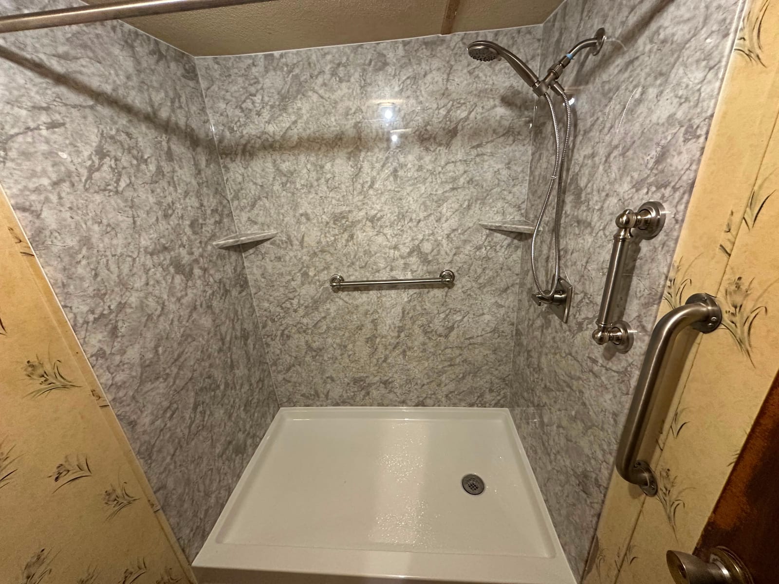 Tub-to-shower conversion with a low-threshold pan and handheld shower