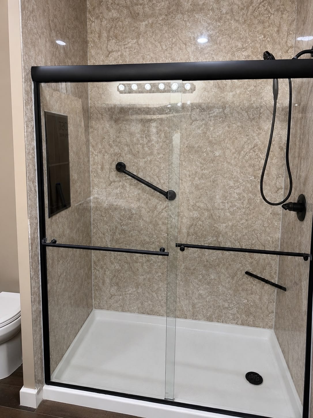 Walk-in shower with built-in bench seat and black fixtures
