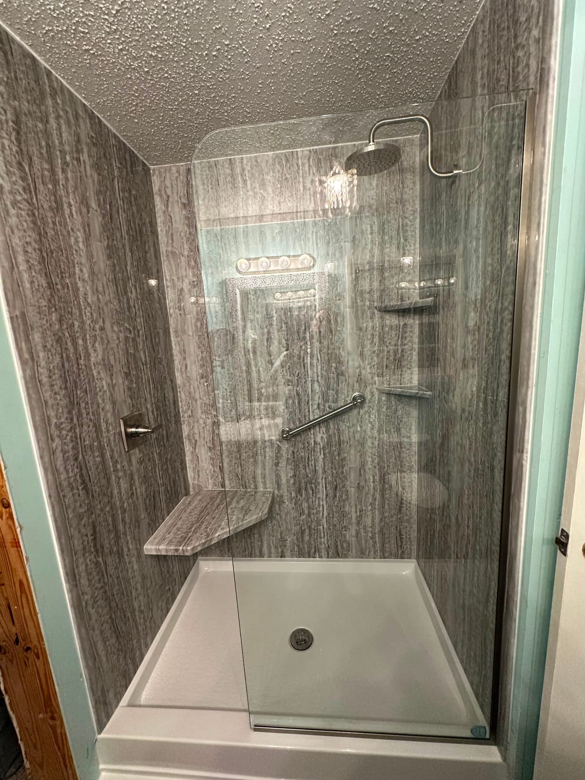 Walk-in shower with corner bench seat and brushed nickel fixtures