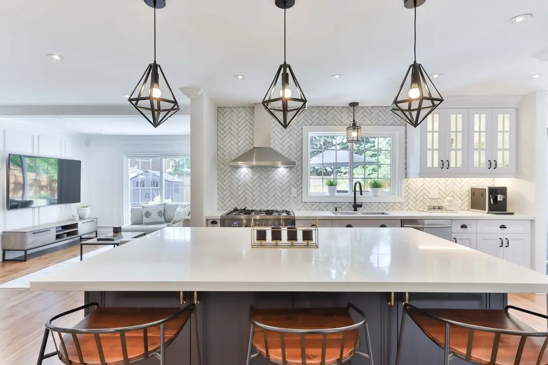 A bright kitchen with white cabinetry, a large island, and pendant lighting, shown for design inspiration only